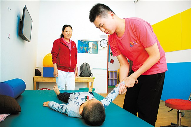 陈庆源（右）为患儿做按摩