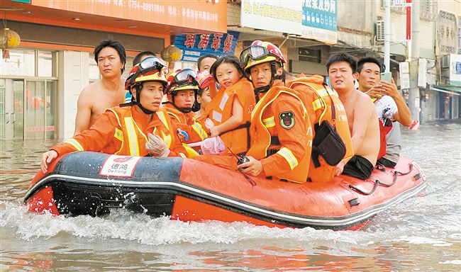 救援人员用橡皮艇救出受灾群众。本报记者 方淦明 摄